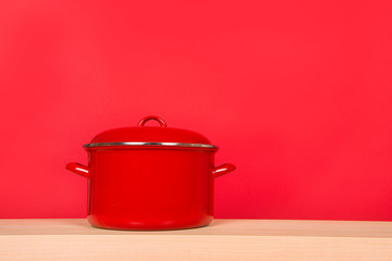 Large red cooking pan on a red background