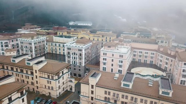 Aerial view of light coloured buildings and walking people in a autumn rainy day. Beautiful city landscape.
