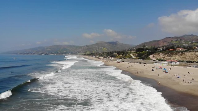 Drone footage of Zuma beach with waves rolling across the soft white sand. Shot in Malibu, California.