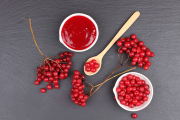 viburnum with juice, jam, tea on black background 