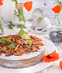 Pie with poppy seeds on a white background. Homemade pastries and red flowers.