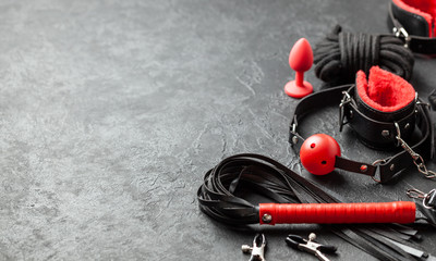 Set of erotic toys for BDSM. The game of sexual slavery with handcuffs, whip, gag and leather...