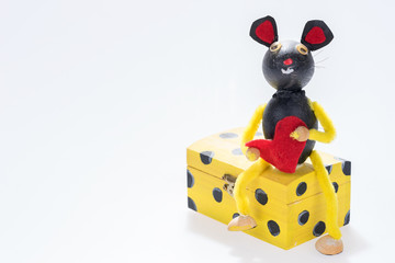 Mouse with red heart sits on the box