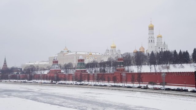 MOSCOW, RUSSIA - DECEMBER, 2018: Handheld slow motion shot of Kremlin walls and churches and Moscow river frozen at winter time. Historical brick walls of Kremlin cover with snow