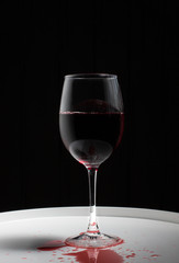Wineglass with red wine on a white table