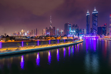 Fototapeta premium Aerial view of light illuminated futuristic skyscrapers in downtown