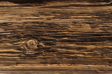 a deeply textured weathered old wooden board with with a single knot breaking the pattern
