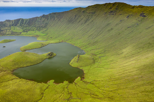 Aerial view of volcanic crater (Caldeirao) with a beautiful lake on the top of Corvo island. Azores islands, Portugal.