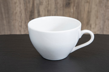 Empty white mug on a wooden table.
