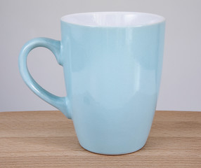 Empty blue mug on a wooden table.