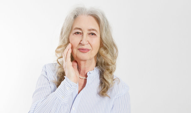 Closeup of smiling senior woman wrinkle face and gray hair. Old mature lady touching her wrinkled skin isolated on white background. Copy space. Banner