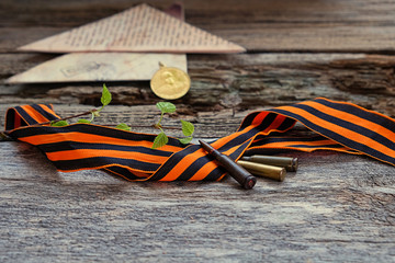 May 9 victory day holiday background. Old wartime letter, rifle bullets and St. George ribbon on...