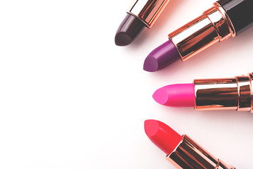 Set of trendy color lipsticks on white background. Minimal composition. Side view, copy space.