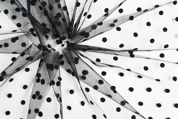 Abstract fabric composition of black tulle material with black cicles on white background. Sewing concept