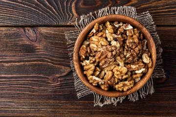 Walnut on dark wooden background.
