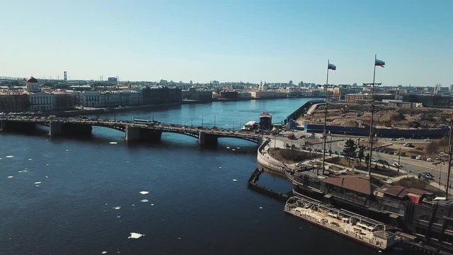 Aerial view of Saint-Petersburg's bridge across the Neva river and moving cars against blue sky. Stock footage. Petersburg landscape