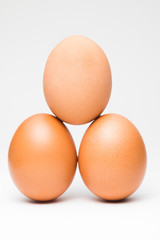 Three chicken eggs in balance pyramid