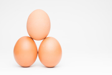 Three chicken eggs in balance pyramid