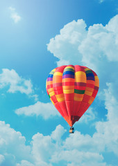 Red air balloon on background of blue sky and clouds