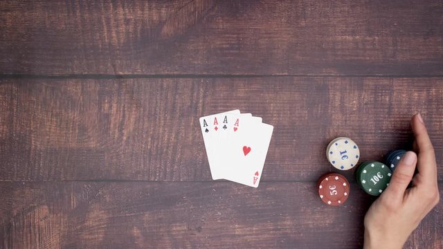 Hand puts four aces and take all the poker chips of the table - Stop motion 