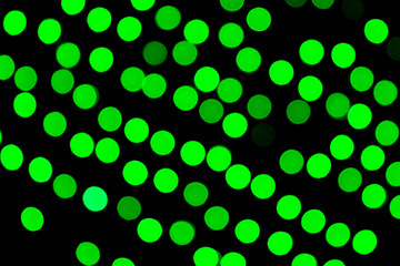 Unfocused abstract green bokeh on black background. defocused and blurred many round light