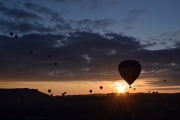 Sunrise and balloons. Beautiful background of the balloon and the sunset.Cappadocia. Turkey. Göreme. Nevşehir. Türkiye. 8. 04. 2019. Balloons flying over the rocky landscape in Cappadocia Turkey. View