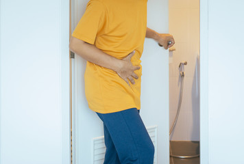Male having painful stomachache and diarrhea in front of restroom bowl after wake up in the morning