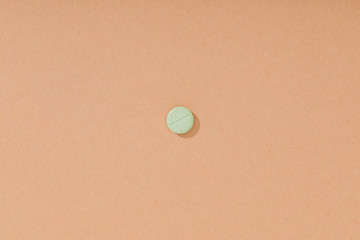 Top view of green pill on brown surface