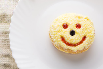 Smiley donut on a white plate, donut with white background  .