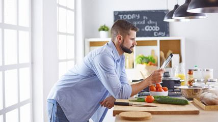 Smiling and confident chef standing in large kitchen