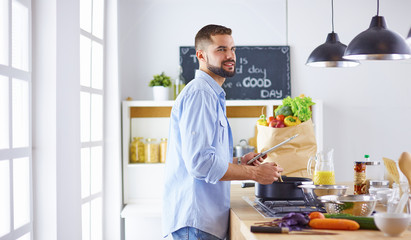 Smiling and confident chef standing in large kitchen