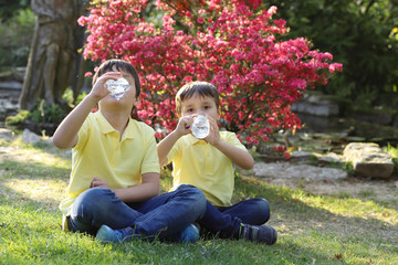 niños en el jardín bebiendo agua de botellas de plástico