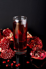 Fresh pomegranate juice. Pomegranate. On a black background. Copy space.