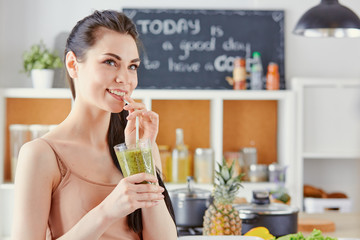 a young girl drinks a cocktail on a kitchen