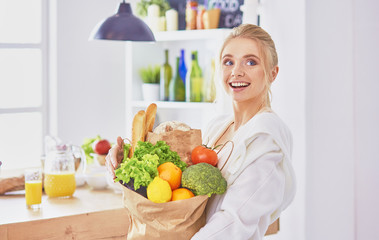 Young woman holding grocery shopping bag with vegetables Standi