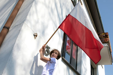 The boy is hanging a flag. Polish National Day of the Third of May, Constitution Day Flag Day,...