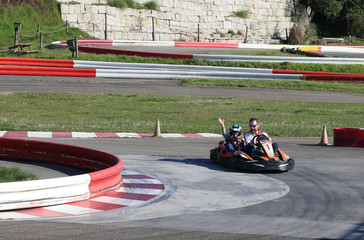padre e hijo en un kart biplaza en un circuito de carreras