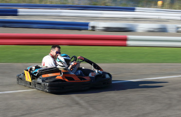 padre e hijo en un kart biplaza en un circuito de carreras