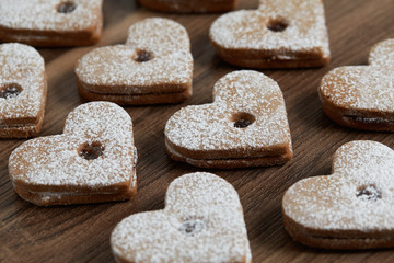 Close up of freshly baked homemade Christmas sugar cookies with jam on a wooden background