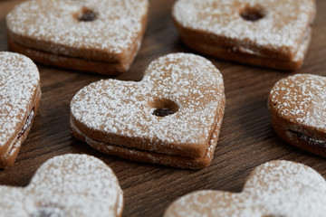Close up of freshly baked homemade Christmas sugar cookies with jam on a wooden background
