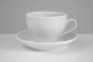 White mug and saucer on a white background.