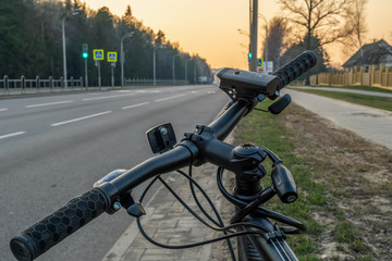 Fototapeta na wymiar Bicycle in the city at sunset. Steering wheel close-up. No man