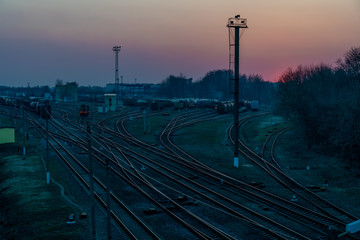 Obraz na płótnie Canvas Railway tracks with freight trains in the evening after sunset