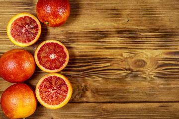 Red blood oranges on wooden table. Top view