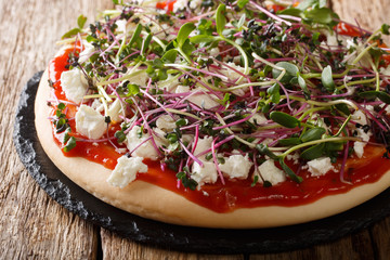 Dietary vegetarian pizza with feta and fresh mix micro green close-up. horizontal