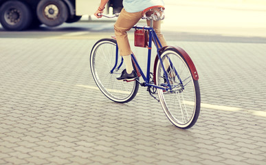 Naklejka premium people, style and lifestyle - hipster man riding fixed gear bike on city street