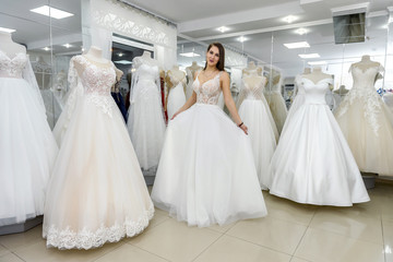 Bride in wedding dress fitting it in atelier