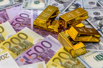 Golden ingot on american dollars and euro banknotes