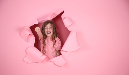 little girl playing superhero on pink background © puhimec