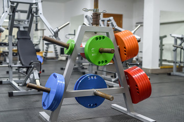 Colorful weights in gym for training with barbell